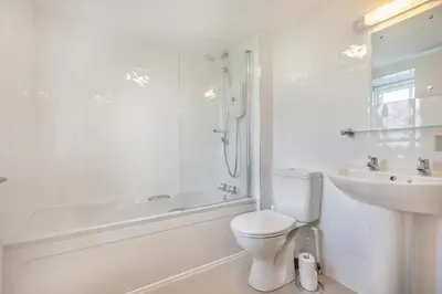 a white bathroom with a toilet and a sink at 1 Bed in Rinsey oc-1chapl in Praa Sands