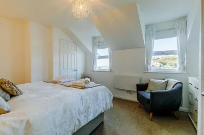 a bedroom with a bed and a chair and windows at 3 Bed in Porthleven oc-1seav in Porthleven