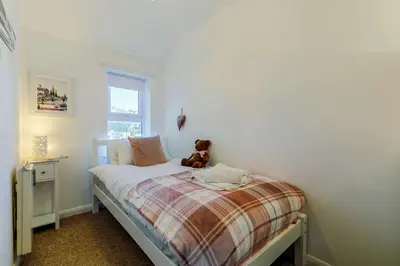 a teddy bear sitting on a bed in a bedroom at 3 Bed in Porthleven oc-1seav in Porthleven