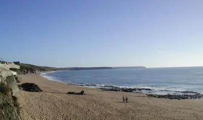 a beach with two people walking on the sand at 3 Bed in Porthleven oc-7bayvi in Porthleven