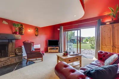 a living room with red walls and a fireplace at 1 Bed in Trehunist oc-chretr in Quethiock
