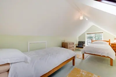 a white bedroom with a bed and a dresser at 2 Bed in Helford oc-hcview in Helford