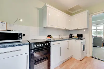 a kitchen with white cabinets and a stove top oven at 2 Bed in Helford oc-hcview in Helford