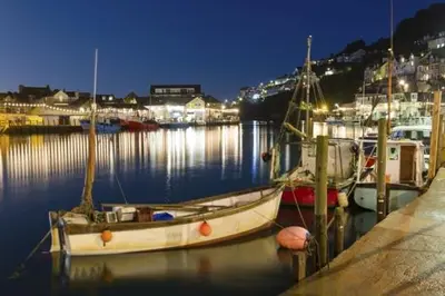 a group of boats docked in a harbor at night at 4 Bed in Looe oc-l30047 in Looe
