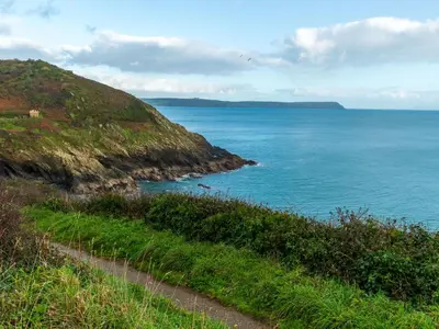 a path on a hill next to the ocean at Holiday Home Mariners Rest by Interhome in Mevagissey
