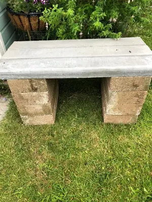 a stone bench sitting on top of grass at Vine Cottage in Penpillick