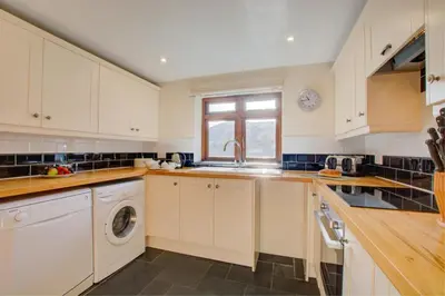 a kitchen with white cabinets and a washer and dryer at 1 Bed in St. Merryn oc-nel42 in St Merryn
