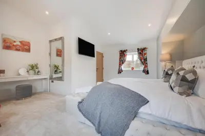 a bedroom with a white bed and a television at 4 Bed in Horningtops oc-northt in Menheniot
