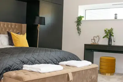 a bedroom with a bed with a bench in it at 4 Bed in Horningtops oc-northt in Menheniot