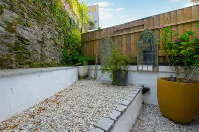 a courtyard with a fence and a potted plant at 4 Bed in Fowey oc-nend in Fowey