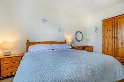 a bedroom with a large bed with a blue comforter at 3 Bed in Padstow oc-p00131 in St Merryn