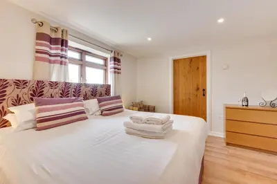 a bedroom with a large white bed with towels on it at 3 Bed in Padstow oc-p00281 in St Merryn