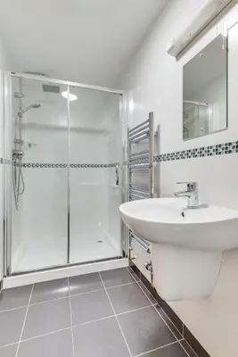 a white bathroom with a shower and a sink at 3 Bed in Padstow oc-p00281 in St Merryn