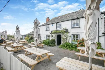 a group of picnic tables in front of a building at 2 Bed in Padstow oc-p00398 in St Merryn