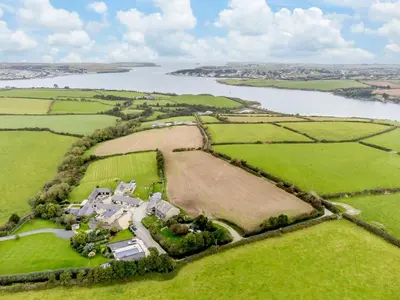 an aerial view of a house in a field next to a lake at 3 Bed in Wadebridge oc-p00421 in Saint Issey