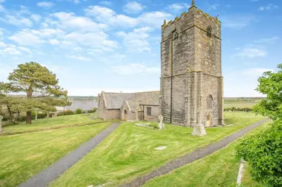an old church with a tower in the middle of a field at 1 Bed in Padstow oc-p00485 in St Merryn