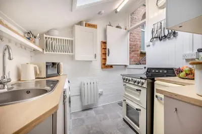 a kitchen with white cabinets and a sink and a stove at 2 Bed in Padstow oc-p00509 in Padstow