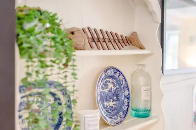 a shelf with blue and white plates and a glass bottle at 2 Bed in Padstow oc-p00509 in Padstow