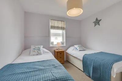 a bedroom with two beds and a window at 3 Bed in St. Merryn oc-p00701 in St Merryn