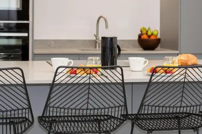 a kitchen counter with two chairs and a table with food at 1 Bed in Mitchell oc-p00750 in Mitchell