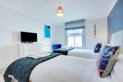 a bedroom with two beds and a tv at 2 Bed in Fowey oc-pont in Fowey
