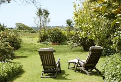 two chairs sitting in the grass in a garden at Tregadjack Barn in Crowan