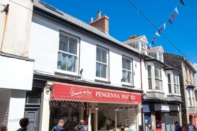 a shop with a red awning on a street at 4 Bed in St. Ives oc-uppcr in St Ives