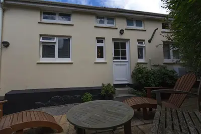 a table and chairs in front of a house at 3 Bed in St Ives oc-weshs in St Ives