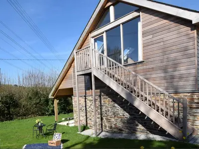 a house with a large window and a staircase at Fernsplatt Farm Lodge in Truro