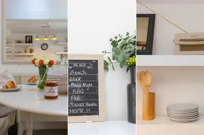 a kitchen with a table with a chalkboard on the wall at Reflections in St Ives