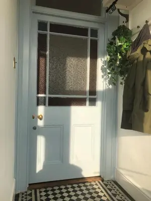 a blue door in a room with a checkered floor at The Nest, Central Falmouth, 10 mins to the beaches and off street parking in Falmouth