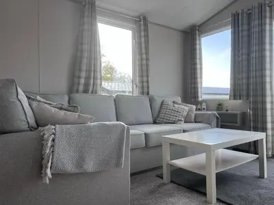 a living room with a couch and a table at Porthcurno 4, Silverbow Country Park in Perranzabuloe