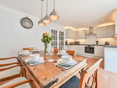 a kitchen and dining room with a wooden table and chairs at Holiday Home Sea Breeze by Interhome in St Austell