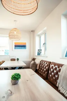 a living room with a brown leather couch and a table at Mawgies in Saint Ervan