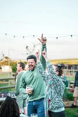 a man and a woman raising their hands in the air at Mawgies in Saint Ervan