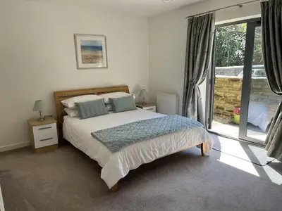 a bedroom with a bed and a large window at The Waterwheel Apartment, Charlestown in Charlestown