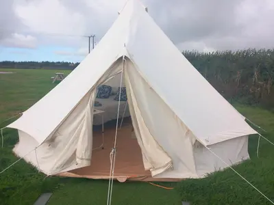 a white tent in the middle of a field at Hawk's View Bell Tent at Higher Hawksland Farm in Saint Issey