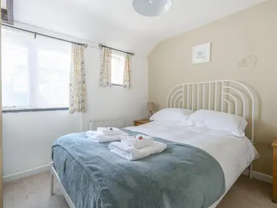 a bedroom with a bed with two towels on it at Cross Cottage in Saint Breward