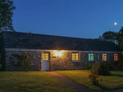 a stone house with a light on the side of it at Drovers in Lanteglos