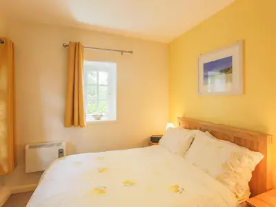 a bedroom with a bed and a window at Drovers in Lanteglos