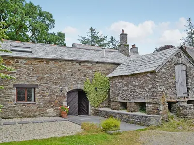 an old stone building with a large door at The Granary in Egloskerry