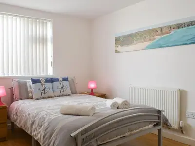a bedroom with a bed with two towels on it at Palm Villa in Saint Columb Minor