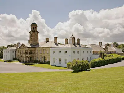 a large white building with a clock tower on top at 2 The Courtyard in Portreath