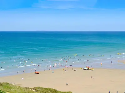 a group of people on a beach near the ocean at The Old Dairy in Mount Hawke