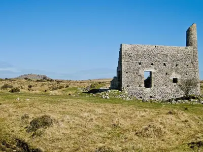 an old stone building on a hill in a field at Dove Cottage in Lezant