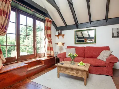 a living room with a red couch and a table at Alyshan in Merrymeet