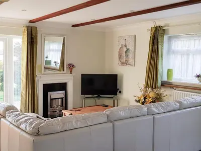 a living room with a white couch and a tv at Badgers Drift in Doublebois