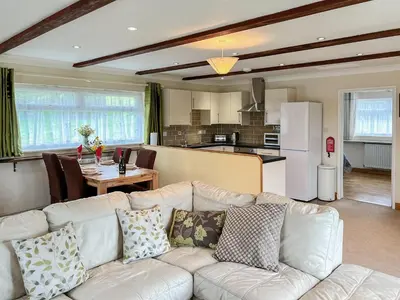 a living room with a white couch and a kitchen at Badgers Drift in Doublebois