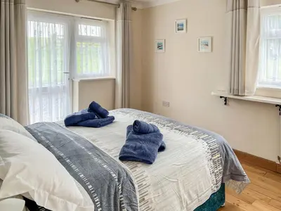a bedroom with two blue towels on a bed at Badgers Drift in Doublebois