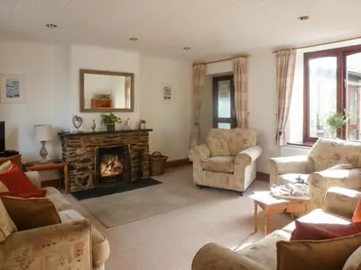 a living room with couches and a fireplace at Penty Rosen in Pentewan